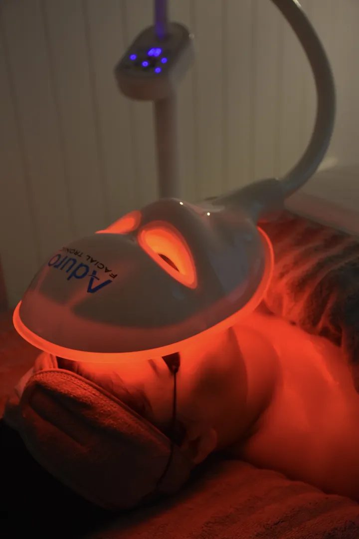 LED light therapy facial treatment device in use.