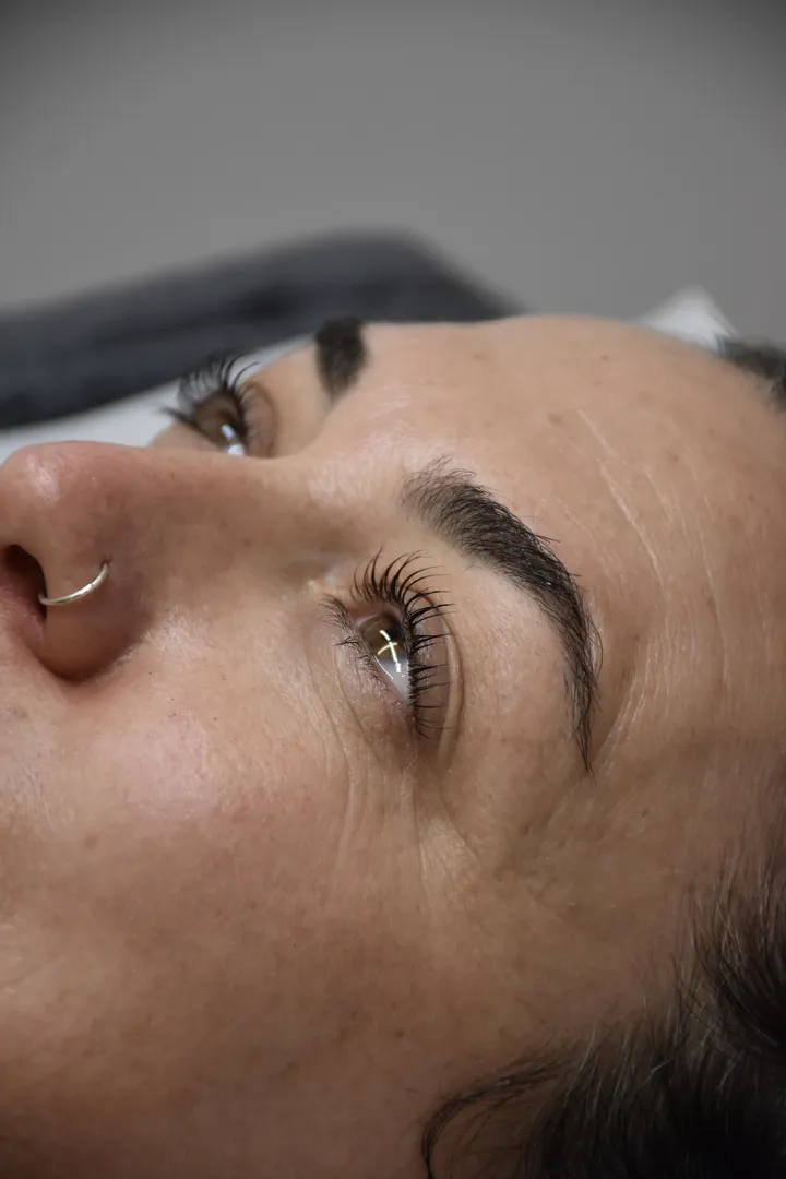 Close-up of woman's face with nose piercing.